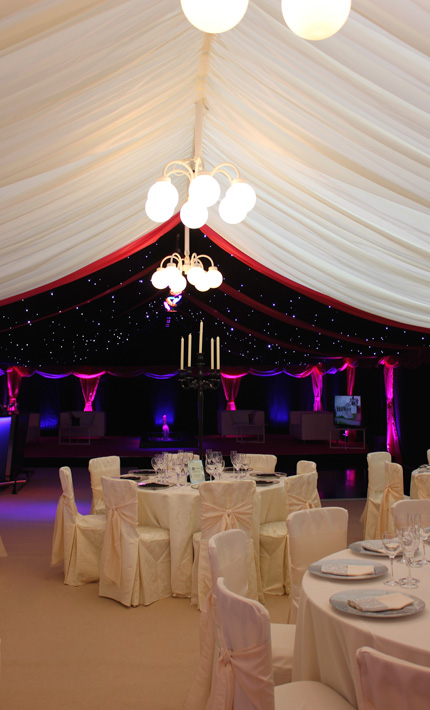 Marquee with black star cloth ceiling, globe chandeliers, and chill out area
