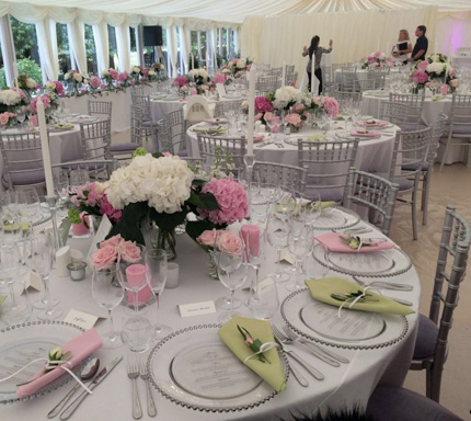 Wedding marquee with tables fully set up for the guests
