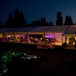 Evening wedding reception with both indoor and outdoor coloured lighting