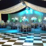 Party Marquee with ivory star cloth ceiling and event lighting, dance floor and table decorations