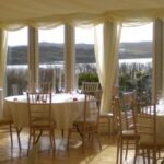 Marquee decorated for a party setting with drinks bar and glazed windows with views to loch