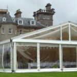 Wedding marquee in a country house setting with clear gables and panoramic window walls