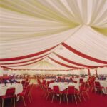 Ceiling overlays in matching colours with a red carpet in a fully finished marquee