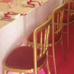 Gold bentwood chair with a red seat pad