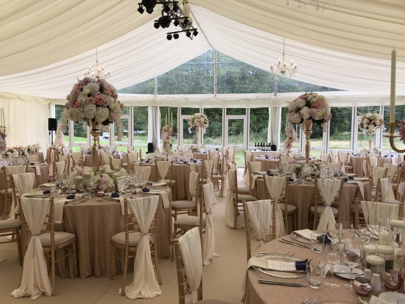 Wedding marquee with a clear gable and solid glazed opening windows with the tables set for the guests