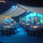 Party Marquee with ivory star cloth ceiling and event lighting, dance floor and table decorations
