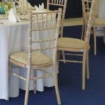 Chiavari chairs and tables within a carpeted corporate marquee