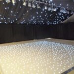 Party Marquee with black star cloth ceiling and event lighting and LED dance floor lighting