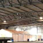 Marquee being used for TV filming within a large empty warehouse