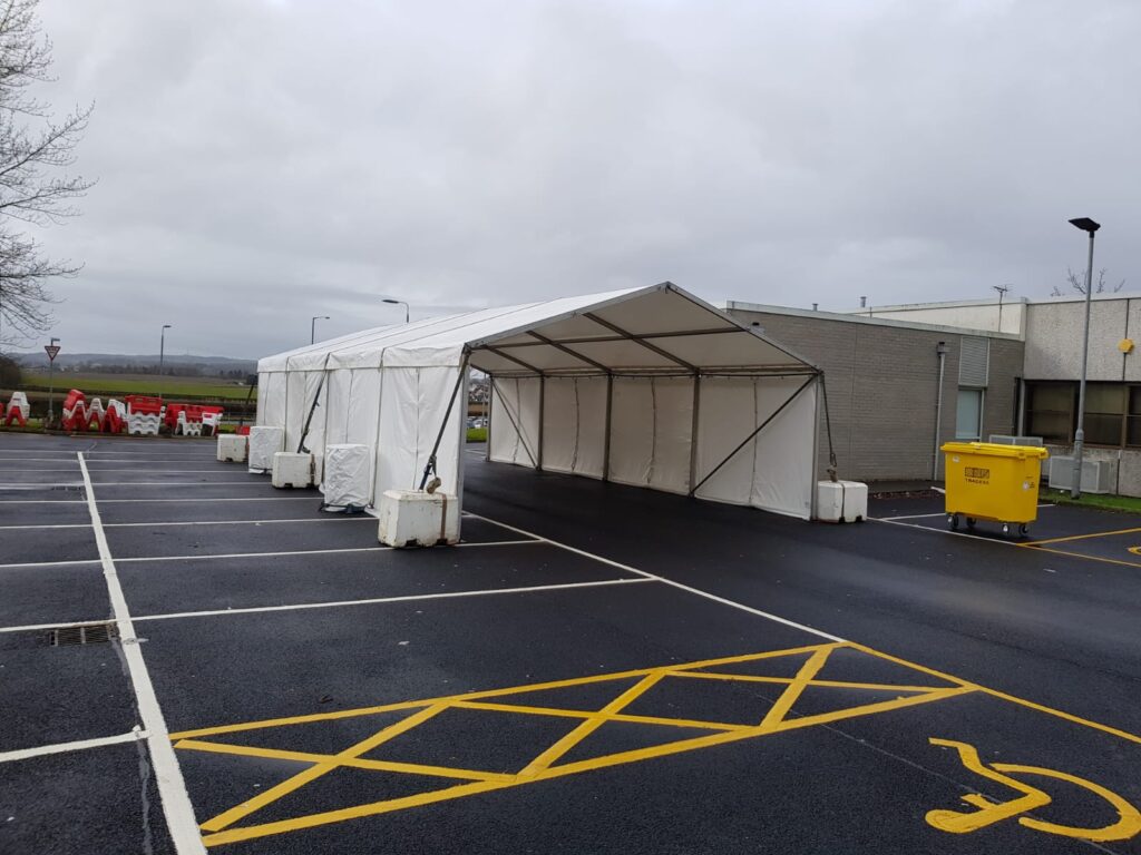 Drive through Covid testing area secured by concrete ballast blocks and water ballast barrels within hospital grounds in Ayrshire