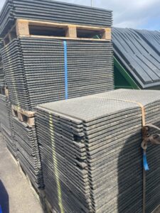 Pedestrian matting for ground protection stacked up on pallets in the yard