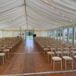 Soft festoon lighting and solid glazing in a wedding ceremony marquee at Inveraray Castle