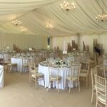 Crystal chandeliers in a fully lined wedding marquee